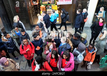 Gruppe der Schule Kinder warten auf einen Bus bei einem Besuch in der Oxford Street in London England UK KATHY DEWITT Stockfoto