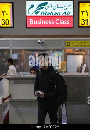 Teheran, Iran. 14 Dez, 2019. Verläßt der Mann eine Mahan Air Zähler nach dem Check-in am Flughafen Mehrabad in Teheran, Iran, Dez. 14, 2019. Das US-Finanzministerium am Mittwoch neue Sanktionen gegen die iranische Fluggesellschaft Mahan Air und die Schifffahrt und ihm vorwirft, er' transportieren Tödliche Hilfe aus dem Iran Jemen auferlegt." Der iranische Organisation für zivile Luftfahrt (CAO) die negativen Auswirkungen der jüngsten US-Sanktionen gegen Fluggesellschaften der Islamischen Republik entlassen, Tehran Times Tageszeitung berichtete am Freitag. Credit: Ahmad Halabisaz/Xinhua/Alamy leben Nachrichten Stockfoto