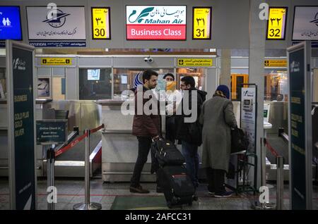 Teheran, Iran. 14 Dez, 2019. Passagiere warten für Check-in am Schalter eine Mahan Air auf dem Internationalen Flughafen Mehrabad in Teheran, Iran, Dez. 14, 2019. Das US-Finanzministerium am Mittwoch neue Sanktionen gegen die iranische Fluggesellschaft Mahan Air und die Schifffahrt und ihm vorwirft, er' transportieren Tödliche Hilfe aus dem Iran Jemen auferlegt." Der iranische Organisation für zivile Luftfahrt (CAO) die negativen Auswirkungen der jüngsten US-Sanktionen gegen Fluggesellschaften der Islamischen Republik entlassen, Tehran Times Tageszeitung berichtete am Freitag. Credit: Ahmad Halabisaz/Xinhua/Alamy leben Nachrichten Stockfoto