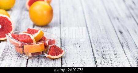 Teil von geschnittenen Grapefruits auf einem alten Holztisch (selektive Fokus, Nahaufnahme) Stockfoto