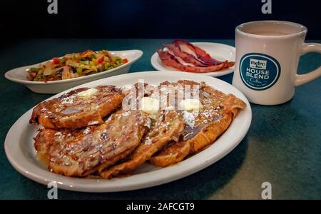 Croissant French Toast ist mit Speck und hashbrowns für Frühstück bei der Metro Diner, 29. Juli 2018, in Huntsville, Alabama gekoppelt. Stockfoto