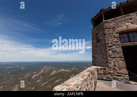 Der Stein und Mörtel Gebäude von Black Elk Lookout, früher genannt Harney Peak Lookout, vor blauem Himmel mit einem weit entfernten Querformat auf einem sonnigen da Stockfoto