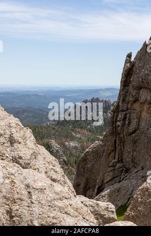 Die Aussicht von Black Elk Peak, früher genannt Harney Peak, mit Quarz Felsformationen ragt aus einem Wald Landschaft und die Berge in der Ferne in Sout Stockfoto