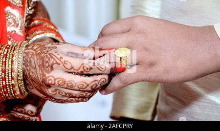 Indische Braut eine Hochzeit Ring am Finger für den Bräutigam Stockfoto