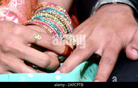 Indische Braut eine Hochzeit Ring am Finger für den Bräutigam Stockfoto