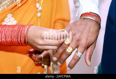 Indische Braut eine Hochzeit Ring am Finger für den Bräutigam Stockfoto