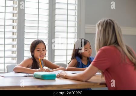 Mutter Hilft Ihren Töchtern Bei Ihren Hausaufgaben Stockfoto