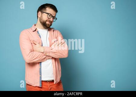 Cute bärtiger Mann mit Brille, steht mit verschränkten Armen und lächelt - naturedly, mit kopieren. Stockfoto