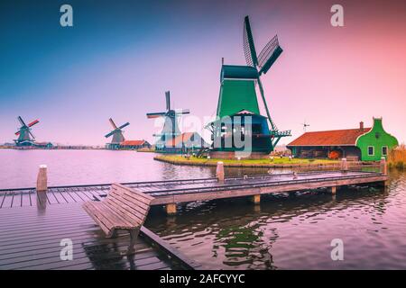 Fantastische rustikale alte holländische Windmühlen in der beliebten Zaanse Schans, touristisches Dorf und Museum bei Sonnenaufgang, in der Nähe von Amsterdam, Zaandam, Niederlande, Europ. Stockfoto