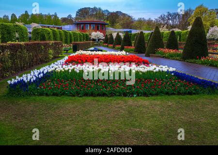 Charmante Gehweg mit bunten Frühling Blumen und frische Tulpen in der niederländischen Ziergarten, Lisse, Niederlande, Europa Stockfoto