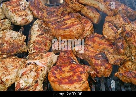 Eine Menge Stücke Fleisch geröstet auf Metall Bars über glühende Holzkohle, close-up Stockfoto