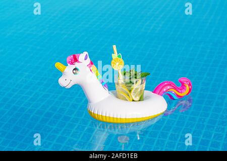 Frischen cocktail Mojito auf aufblasbaren White unicorn Toy am Pool. Ferienhäuser Konzept. Stockfoto