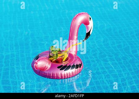 Frischen cocktail Mojito auf aufblasbaren rosa Flamingo Spielzeug am Pool. Ferienhäuser Konzept. Stockfoto