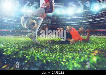 In der Nähe eines Fußball-action Szene mit konkurrierenden Fußball-Spieler im Stadion während einer Nacht überein Stockfoto