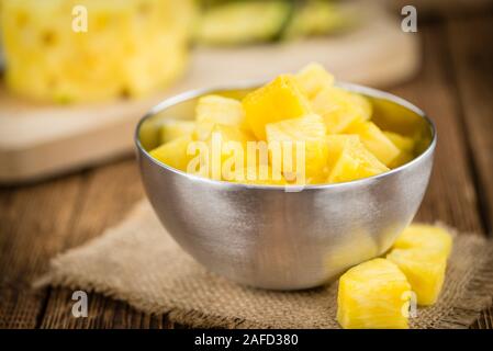 In Scheiben geschnittene Ananas auf einen alten Holztisch als detaillierte Nahaufnahme; selektive Fokus Stockfoto