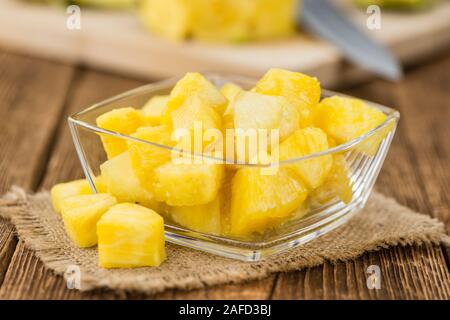 In Scheiben geschnittene Ananas auf rustikalen Holzmöbeln Hintergrund als Nahaufnahme Stockfoto