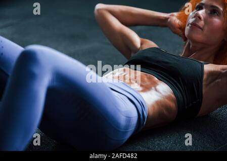Nähe zu sehen. Sportliche rothaarige Mädchen haben fitness Tag in der Turnhalle am Tag. Muskulöse Körper Typ Stockfoto