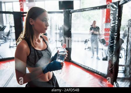 Wasser trinkt. Eine Pause. Sportlerin im Boxring haben Übung Stockfoto