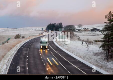 Tabay, Cumbria, Großbritannien. 15. Dezember, 2019. Dezenten Farbtönen in der Morgendämmerung; am frühen Morgen Frost und Schnee Duschen für die tabay Winterlandschaft als Verkehr Köpfe für Shap ein renommierter kalten schwierigen Fahrsituationen Punkt im Allgäu Hochmoore. Credit: MediaWorldImages/Alamy leben Nachrichten Stockfoto