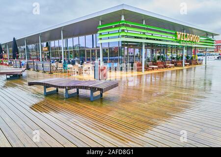 Holzbänke außerhalb der Wildwood Shop an Rushden Seen Einkaufszentrum während einer nassen und regnerischen Wintertag. Stockfoto