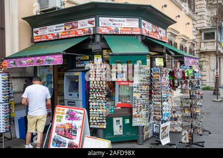 Mann neben News Kiosk Store im Zentrum von Rom, Latium, Italien, wo Postkarten und Zeitschriften erworben werden kann Stockfoto