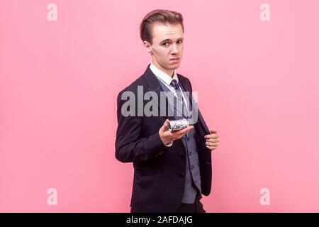 Porträt eines arroganten reichen Geschäftsmann im eleganten Anzug und mit stilvollen Haarschnitt, Bündel von Dollar auf Kamera, mit Geld oder mit Gewinn Stockfoto