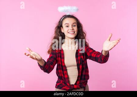 In meine Arme! Portrait von Gutherzigen schönes junges Mädchen mit lockigem Brünette Haare und Spielzeug Heiligenschein über dem Kopf heben die Hände in Willkommen Geste, Ri Stockfoto