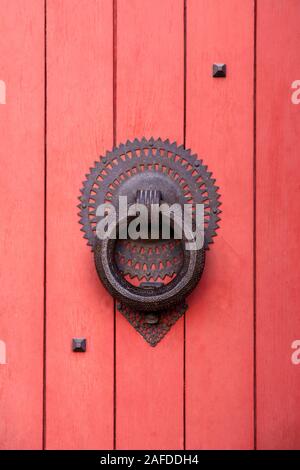 Detail eines roten Holzkirche Eingangstür mit einem metallarbeiten Stockfoto