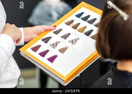 Der Stylist Hand, die eine Palette von haarfarbstoffen Proben im Beauty Salon, aus der Nähe. Stockfoto