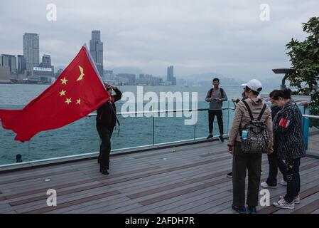 Ein pro-government Demonstrant posiert für ein Foto, während eine chinesische Flagge während der Rallye. Tausende von Regierungsnahen Demonstranten versammelt, Slogans, wave Flags zu schreien und Plakaten zur Unterstützung der Hong Kong Polizei im Umgang mit der Proteste, Hong Kong für die letzten 6 Monate gequält haben. Stockfoto