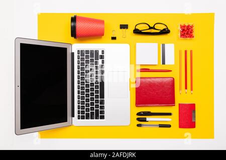 Schul- und Büromaterial liegen fein säuberlich auf gelbem Hintergrund Stockfoto