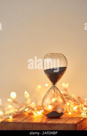 Sanduhr und festliche Girlande Lichter in Bokeh Stockfoto
