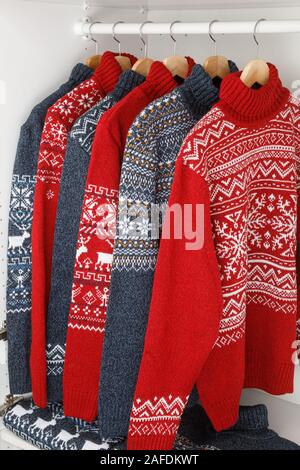 Verschiedene gestrickt Weihnachten rollkragen pullover oder Pullis mit Nordic geometrische Verzierung auf Kleiderbügel im Schrank Rack Stockfoto