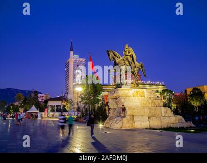 Der Hauptplatz von TiranaThe Et'Hem Bey Moschee, der Osmanischen Uhrturm, die modernen Hotels, die Nationalflagge und die Reiterstatue von skenderbeg Stockfoto