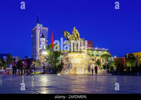 Der Hauptplatz von TiranaThe Et'Hem Bey Moschee, der Osmanischen Uhrturm, die modernen Hotels, die Nationalflagge und die Reiterstatue von skenderbeg Stockfoto