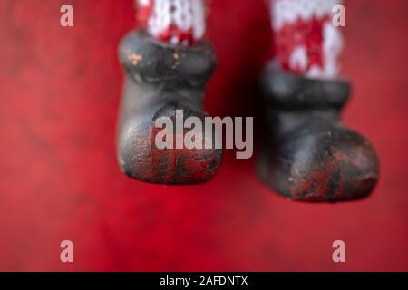 Nahaufnahme Detail der Vintage Schneemann Figur Stiefel auf rotem Hintergrund als Weihnachtsdekoration Stockfoto