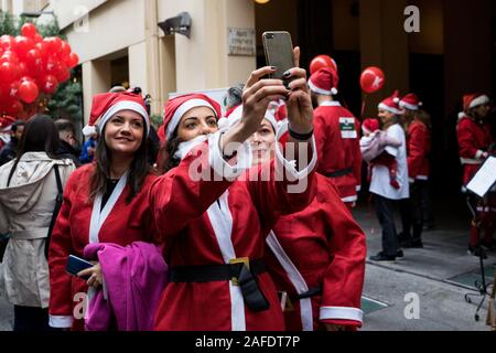 Frauen gekleidet als Santa Clause einen selfie während des Rennens Santa Run ist ein gesellschaftliches Ereignis, das Rennen findet jedes Jahr in vielen Städten während Weihnachten und mit Gewinn unterstützt verschiedene Stiftungen. Stockfoto