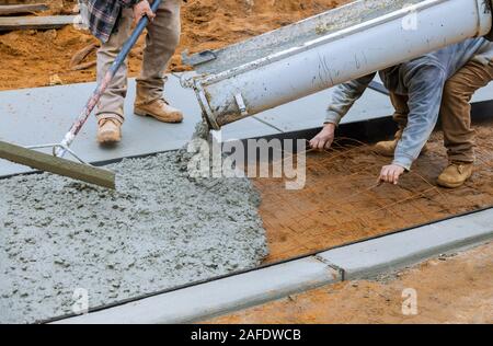 Mischer Lkw Fahrer gießen Beton gießen auf die Stärkung der Metal Bars von Bürgersteig Stockfoto