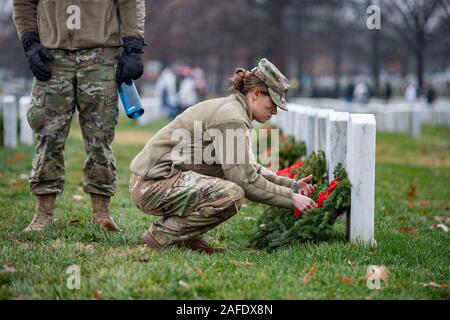 Arlington, Vereinigten Staaten von Amerika. 14. Dezember, 2019. Ein US-Soldat Orte einen Kranz auf dem Grab eines gefallenen service Mitglied während der 28 Kränze über Amerika Tag auf dem Arlington National Cemetery Dezember 14, 2019 in Arlington, Virginia. Mehr als 38.000 Freiwilligen statt Kränze auf jeder Grabstätte auf dem Arlington National Cemetery und anderen Seiten rund um die Nation. Credit: Elizabeth Fraser/DOD/Alamy leben Nachrichten Stockfoto