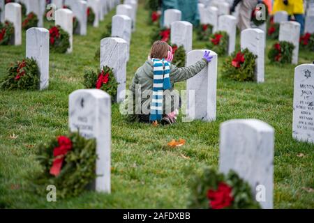 Arlington, Vereinigten Staaten von Amerika. 14. Dezember, 2019. Ein junges Mädchen berührt ein Grab Marker, wie Sie einen Kranz auf dem Grab eines gefallenen service Mitglied während der 28 Kränze über Amerika Tag auf dem Arlington National Cemetery Dezember 14, 2019 in Arlington, Virginia. Mehr als 38.000 Freiwilligen statt Kränze auf jeder Grabstätte auf dem Arlington National Cemetery und anderen Seiten rund um die Nation. Credit: Elizabeth Fraser/DOD/Alamy leben Nachrichten Stockfoto