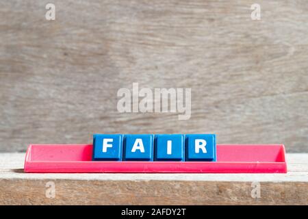 Fliese Brief auf rot Gestell in Wort Messe auf Holz Hintergrund Stockfoto