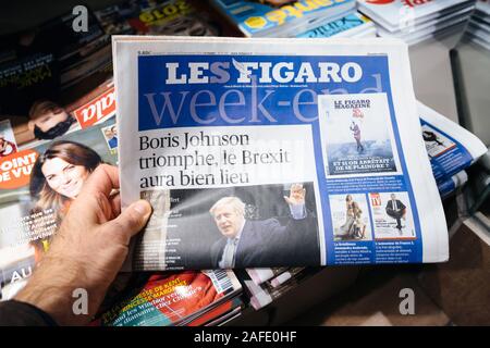 Paris, Frankreich - 14.12.2019: Mann hält in der Nähe der Presse Kiosk am Tag nach der britische Premierminister Boris Johnson die Konservative Partei gewann ein Erdrutsch Anfang Allgemeine parlamentarische Sieg Stockfoto