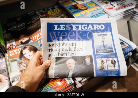 Paris, Frankreich - 14.12.2019: Mann mit Le Figaro Week-End Zeitung bei Presse Kiosk am Tag nach der britische Premierminister Boris Johnson die Konservative Partei gewann ein Erdrutsch Anfang Allgemeine parlamentarische Sieg Stockfoto