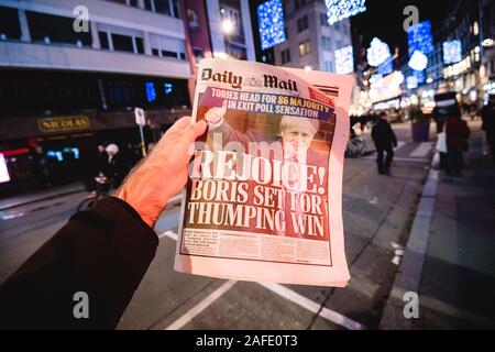 Paris, Frankreich - 14.12.2019: Mann lesen in Stadt bei Nacht britische Daily Mail Zeitung Presse am Tag nach Großbritannien PM Boris Johnson die Konservative Partei gewann ein Erdrutsch Anfang Allgemeine Sieg brexit freuen Stockfoto