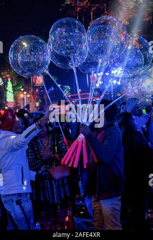 Ein unbekannter Mann verkauf von bunten Luftballons, Spielzeug und Geschenkartikel für junge Kinder auf dem Weihnachtsmarkt Park Street, Kolkata, Indien im Dezember Stockfoto
