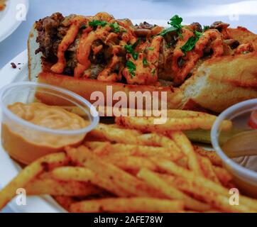 Beef Sandwich und Pommes Frites mit Gewürzen und Saucen Stockfoto