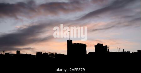 Windsor, Berkshire, Großbritannien. 15. Dezember 2019. UK Wetter: Das legendäre schloss und der Stadt Dächer sind gegen pulsierenden sunrise Farben im Windsor silhouetted läutet einen hellen Anfang nach einer Nacht des schweren Duschen und starke Winde. Credit: Celia McMahon/Alamy Leben Nachrichten. Stockfoto