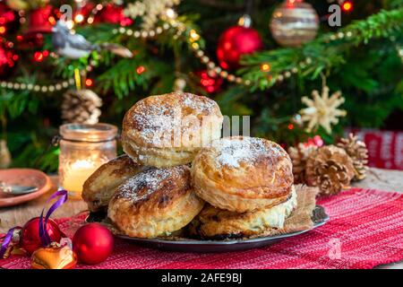 Hausgemachte Weihnachten Blätterteig mince pies mit Weihnachtsbaum im Hintergrund Stockfoto