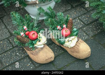 Weihnachten festliche Komposition mit natürlichen Holz- Schuh für St Nikolaus Tag, fichte Äste, Kegel, festliche Home Decor Stockfoto