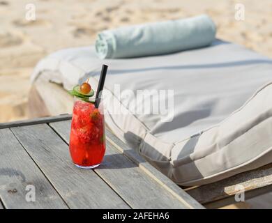 Glas Saft am Strand Tabelle im Sommer Tag. Stockfoto